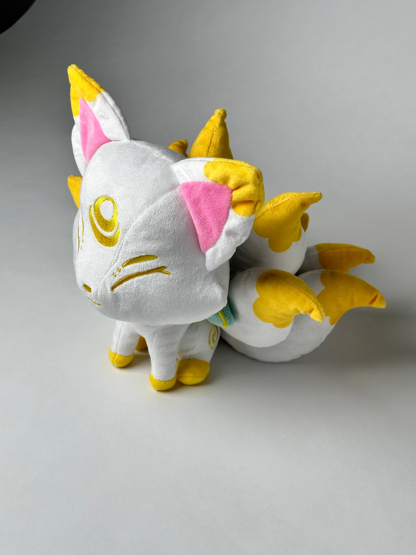 Top view of Serenity, a white, yellow, mint kitsune plush.