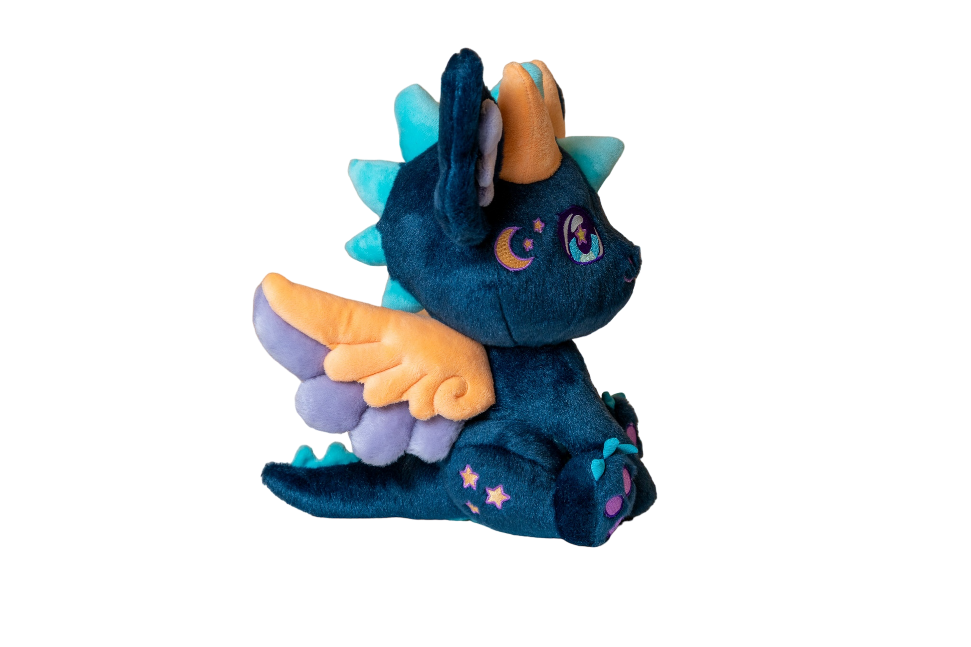Three-quarter cutout view of Calypso, a navy, peach, turquoise dragon plush.