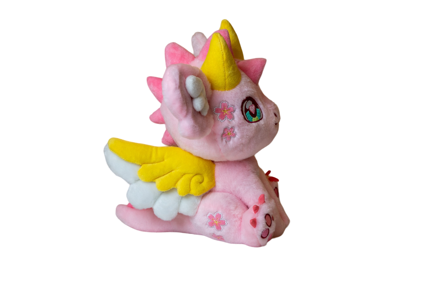 Three-quarter cutout view of Ella, a pink, yellow, white dragon plush.