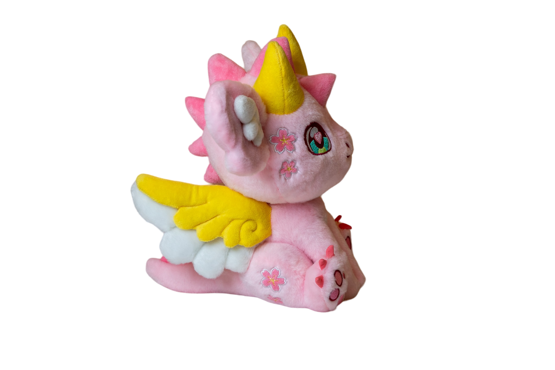 Three-quarter cutout view of Ella, a pink, yellow, white dragon plush.