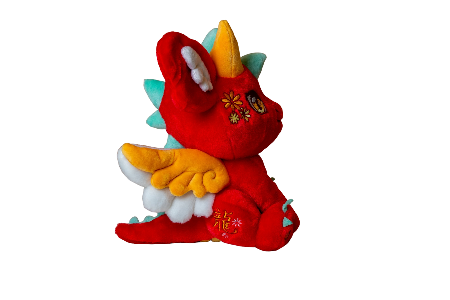 Three-quarter cutout view of Ryu, a red, orange, turquoise dragon plush.