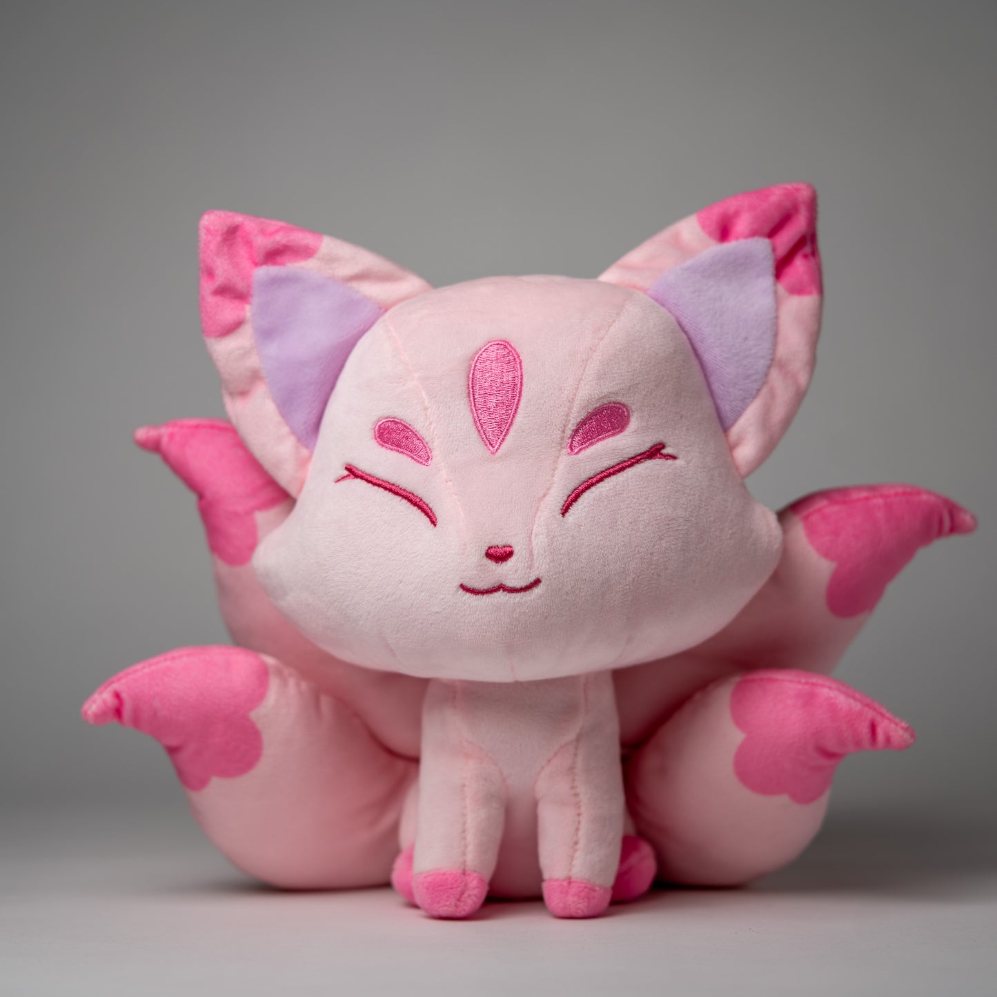 Front view of Sakura, a pink, rose, lavender kitsune plush.