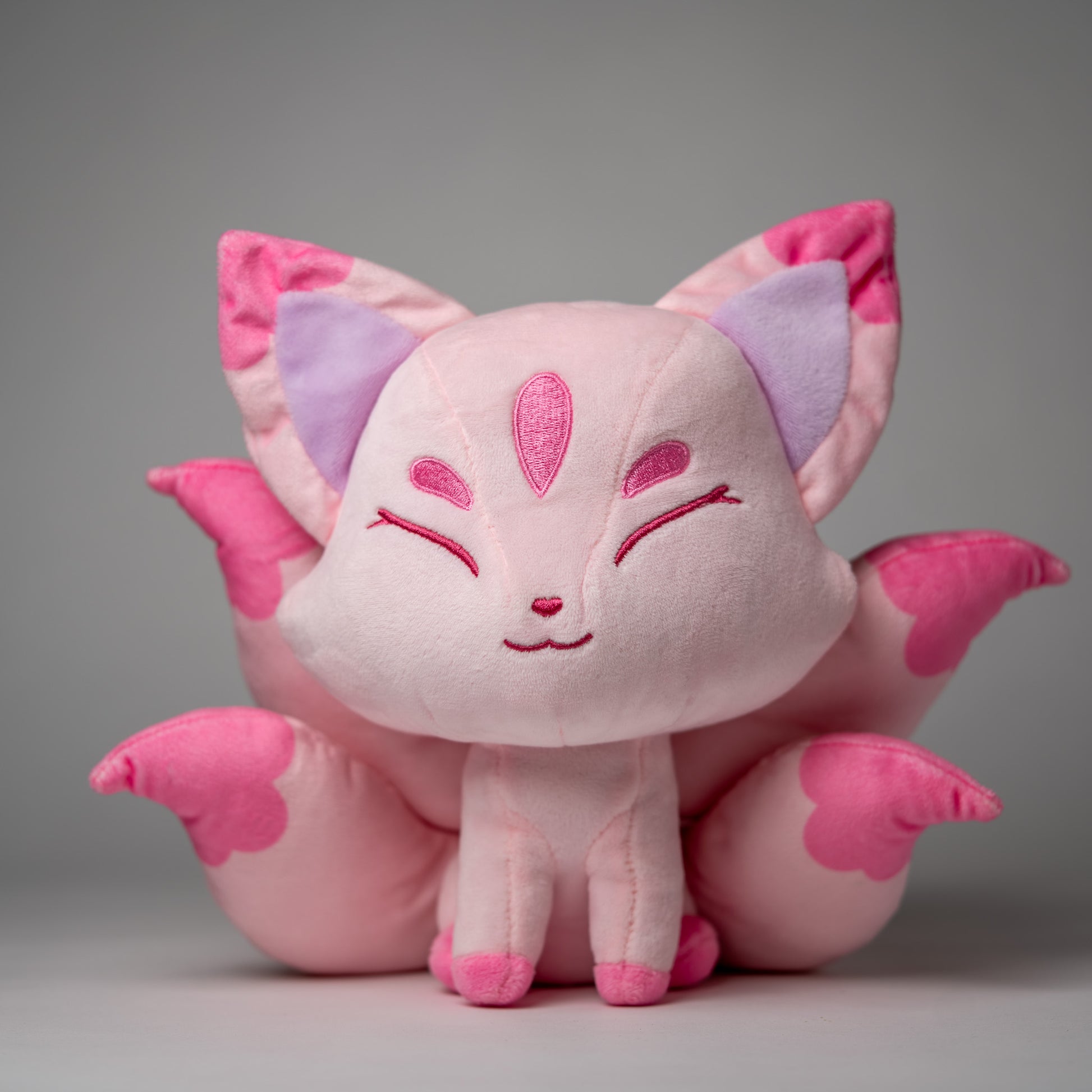 Front view of Sakura, a pink, rose, lavender kitsune plush.