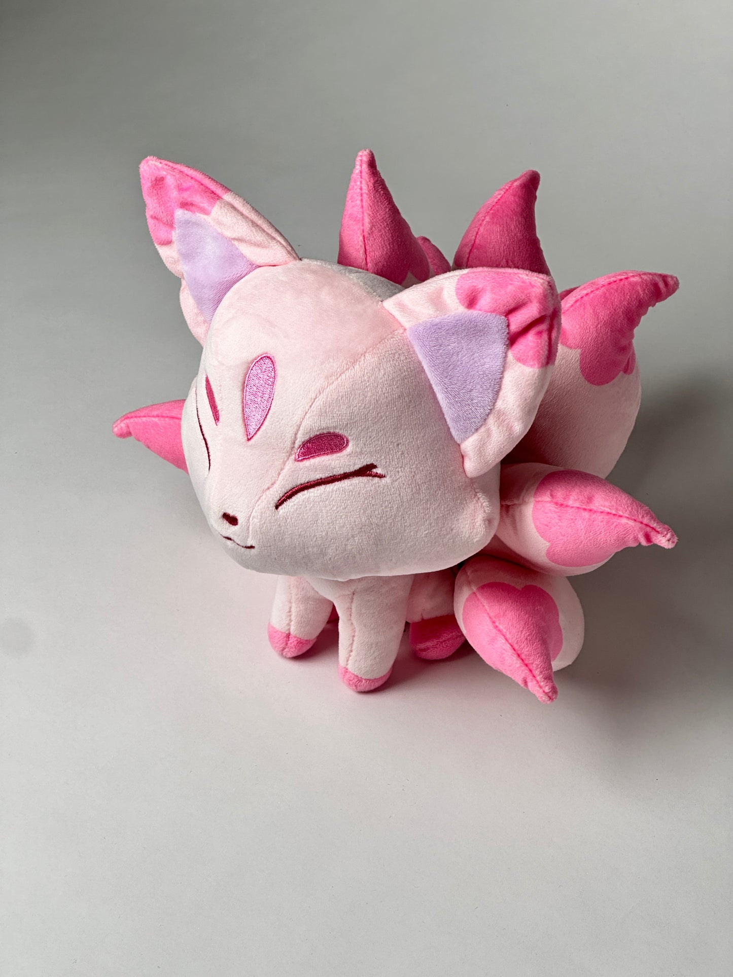 Top view of Sakura, a pink, rose, lavender kitsune plush.