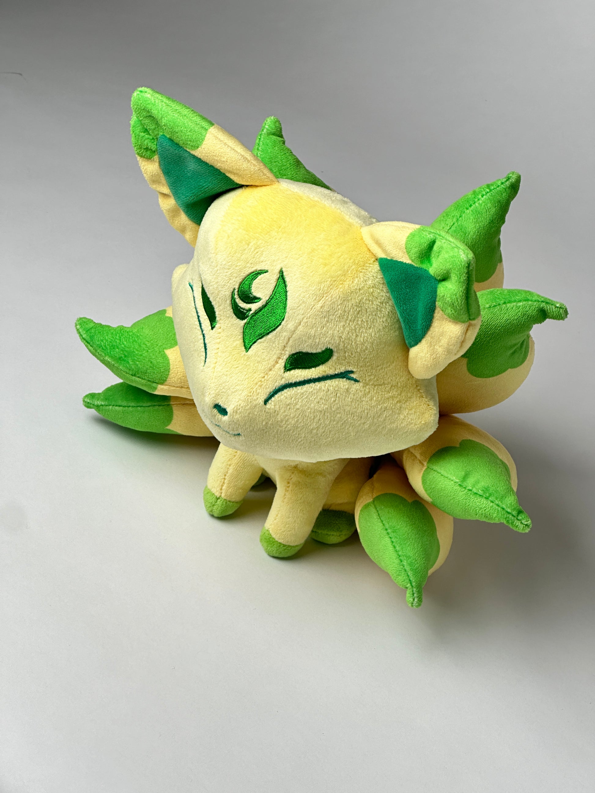 Top view of Silva, a tan, green, yellow kitsune plush.
